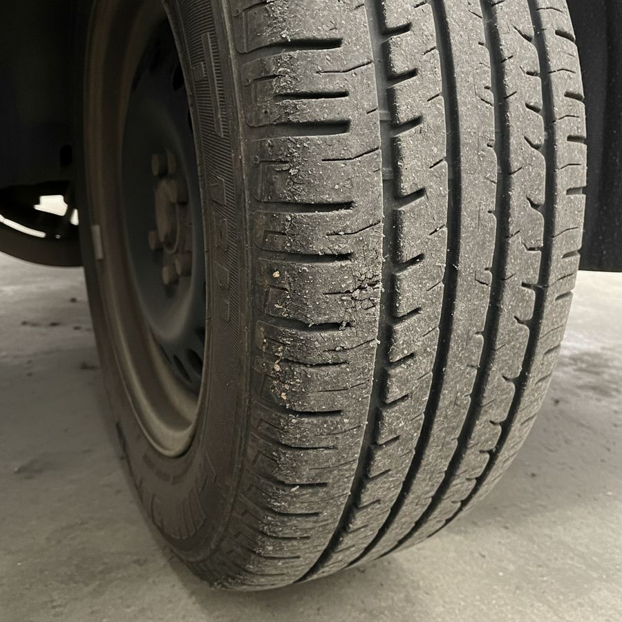 Close-up of a performance tire showing uneven inner edge wear from excessive negative camber